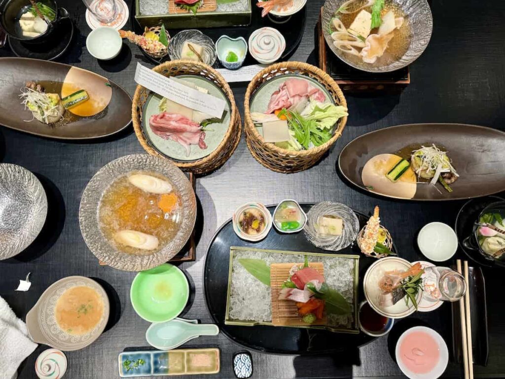 Beautifully arranged traditional Japanese multi-course dinner featuring sashimi, hot pot, and seasonal appetizers.