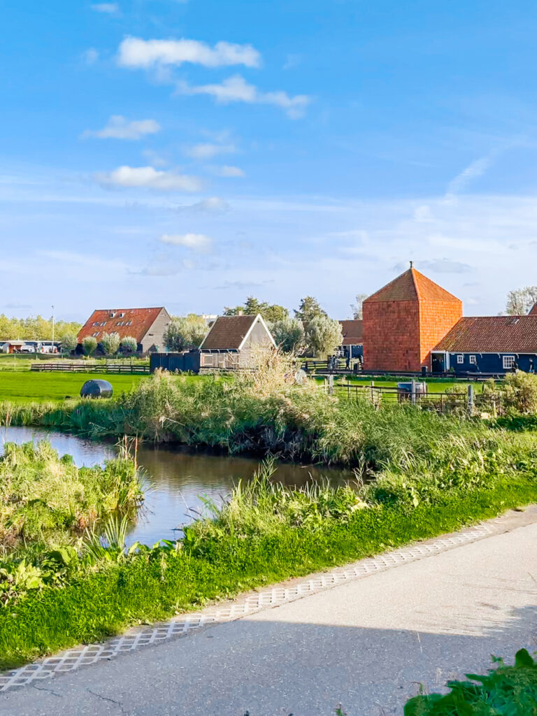 Picturesque wooden houses and windmills reflecting on the water in Zaanse Schans, a must-visit near Amsterdam