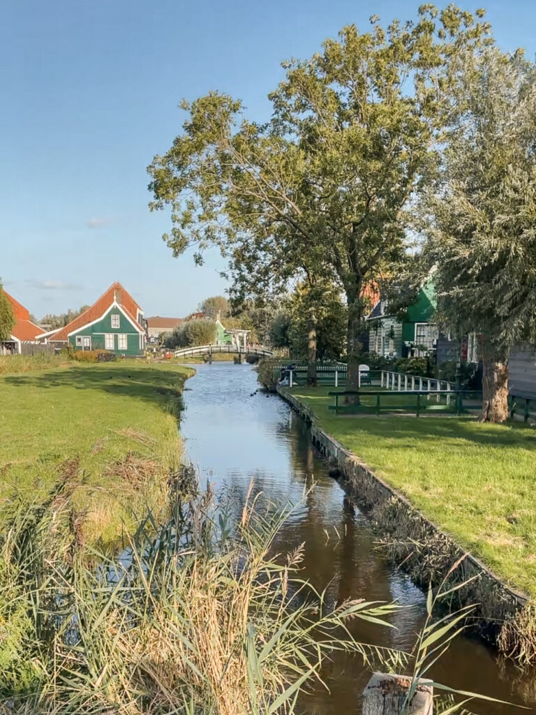 Picturesque wooden houses and windmills reflecting on the water in Zaanse Schans, a must-visit near Amsterdam