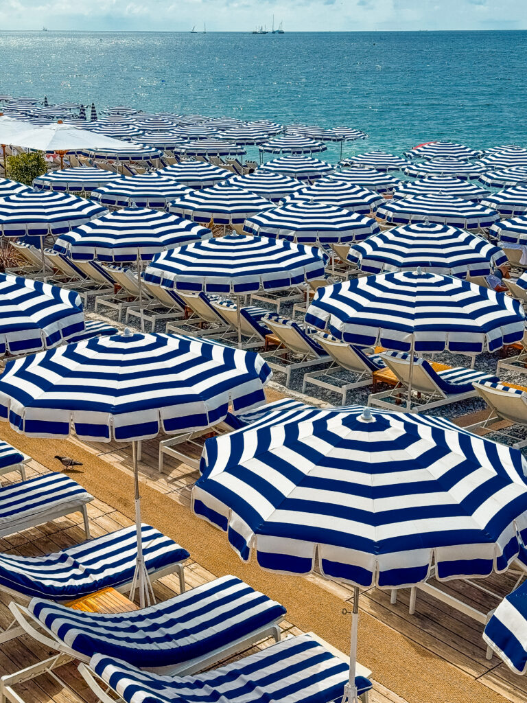 Iconic blue and white striped umbrella at Ruhl plage in Nice, France, seen on the South of France itinerary