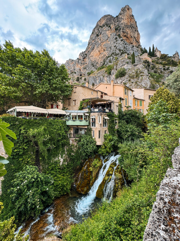 Moustiers-Sainte-Marie a village built onto rock cliffs with a waterfall flowing in the village