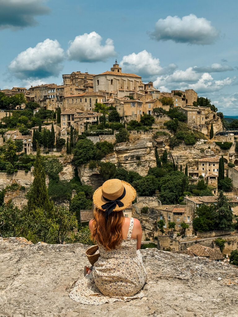 Woman sitting and looking at Gordes, in Luberon Provence

