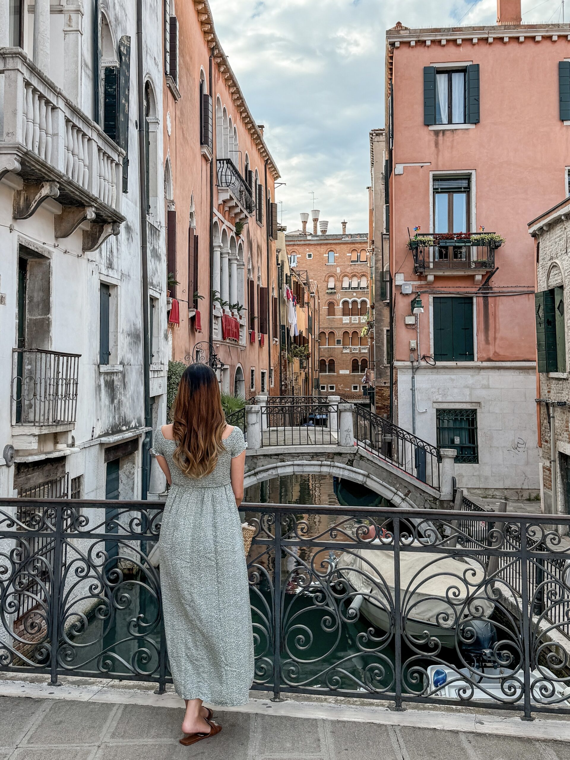 A woman looking at canals and bridges of Venice during her one day in Venice
