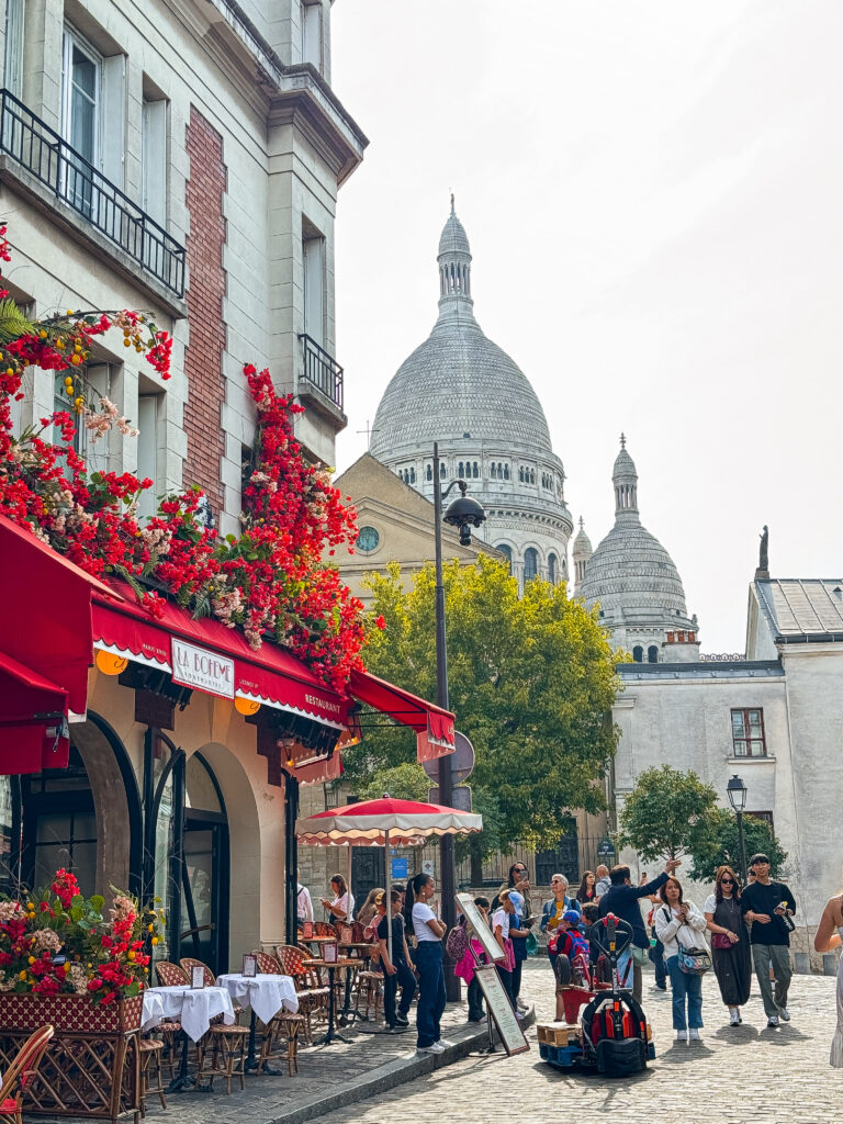 Exploring Montmartre and dining at charming sidewalk cafés like this one with views of the Sacré-Cœur is one of the best things to do in Paris for a quintessentially Parisian experience.