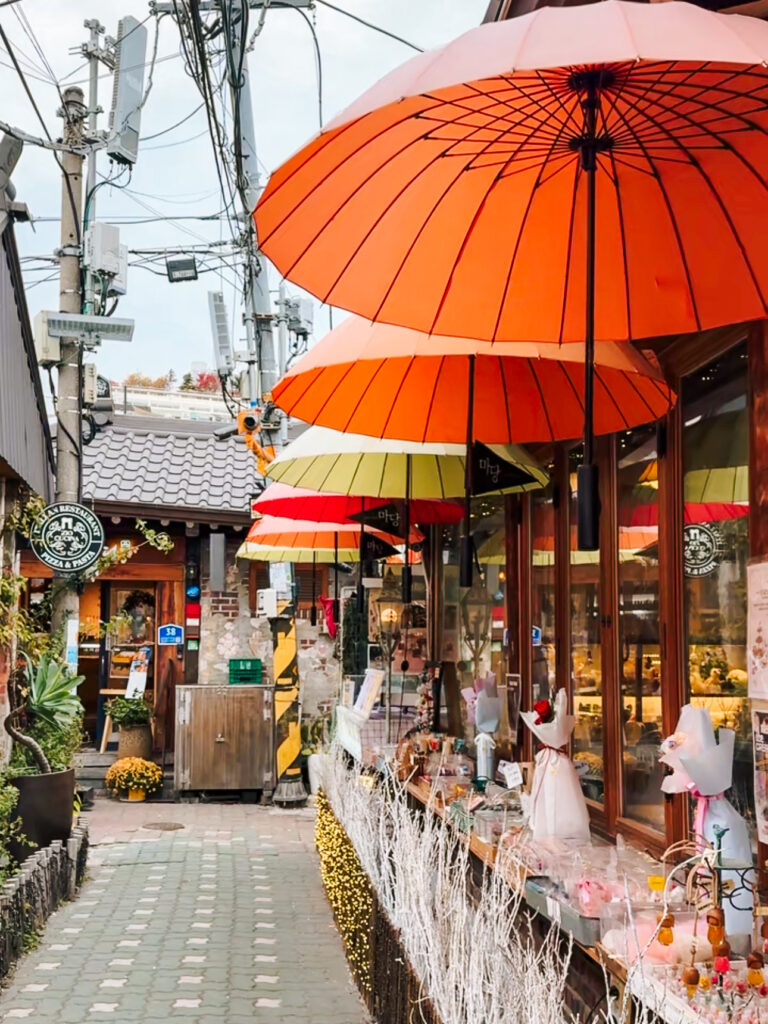 Colorful parasols and boutique storefronts lining a narrow alley in Ikseon-dong, one of Seoul’s most charming and photogenic neighborhoods.