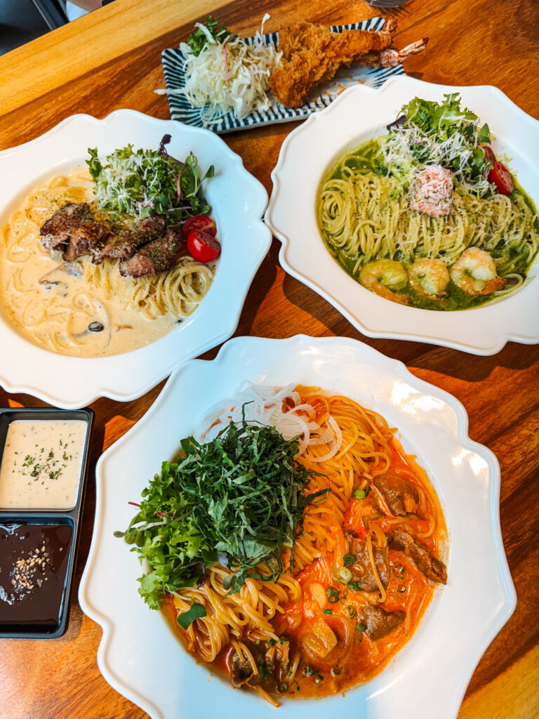 Trio of beautifully plated pasta dishes and fried shrimp cutlets at Yeonnam Toma in Seoul, featuring creamy, pesto, and tomato-based sauces.

