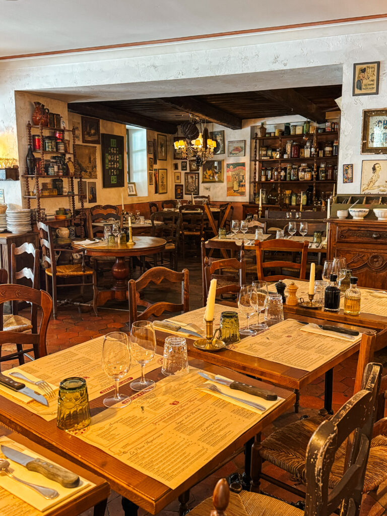 Cozy Provençal dining room with wooden tables, vintage Italian décor, and candlelit ambiance.