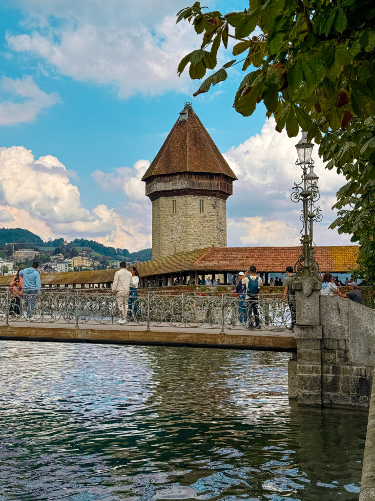 The iconic wooden Chapel Bridge with its medieval stone tower reflecting on the Reuss River.