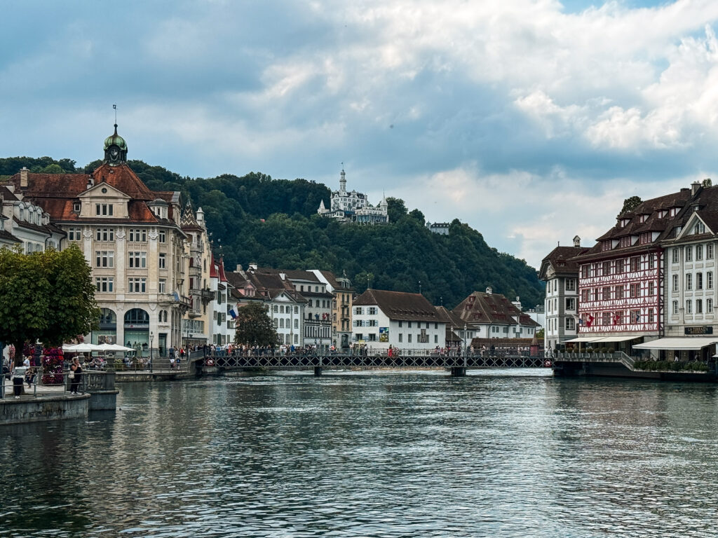 Historic riverside façades with Château Gütsch perched on the hillside in the background.