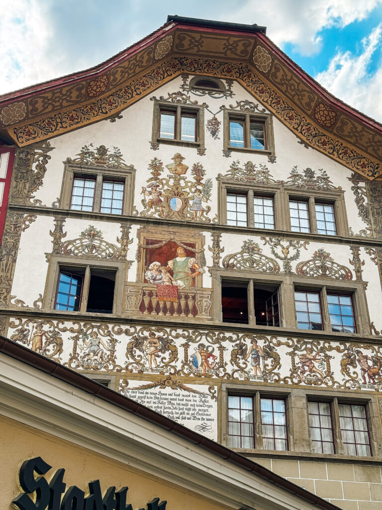 A medieval house in Lucerne decorated with ornate frescoes and detailed painted figures.