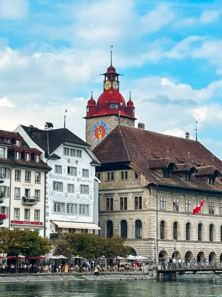 The red-roofed clock tower of the Old Town Hall with riverside restaurants below.