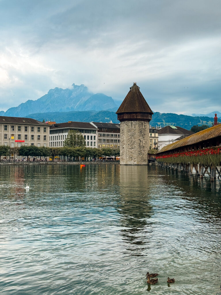 Chapel Bridge and Water Tower reflected in the Reuss River with Mount Pilatus in the distance.