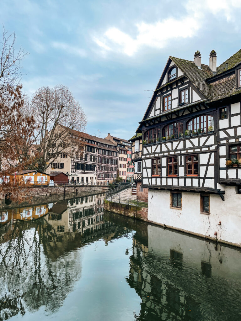 Half timbered houses reflecting on the canal in Petite France Strasbourg on a winter day.