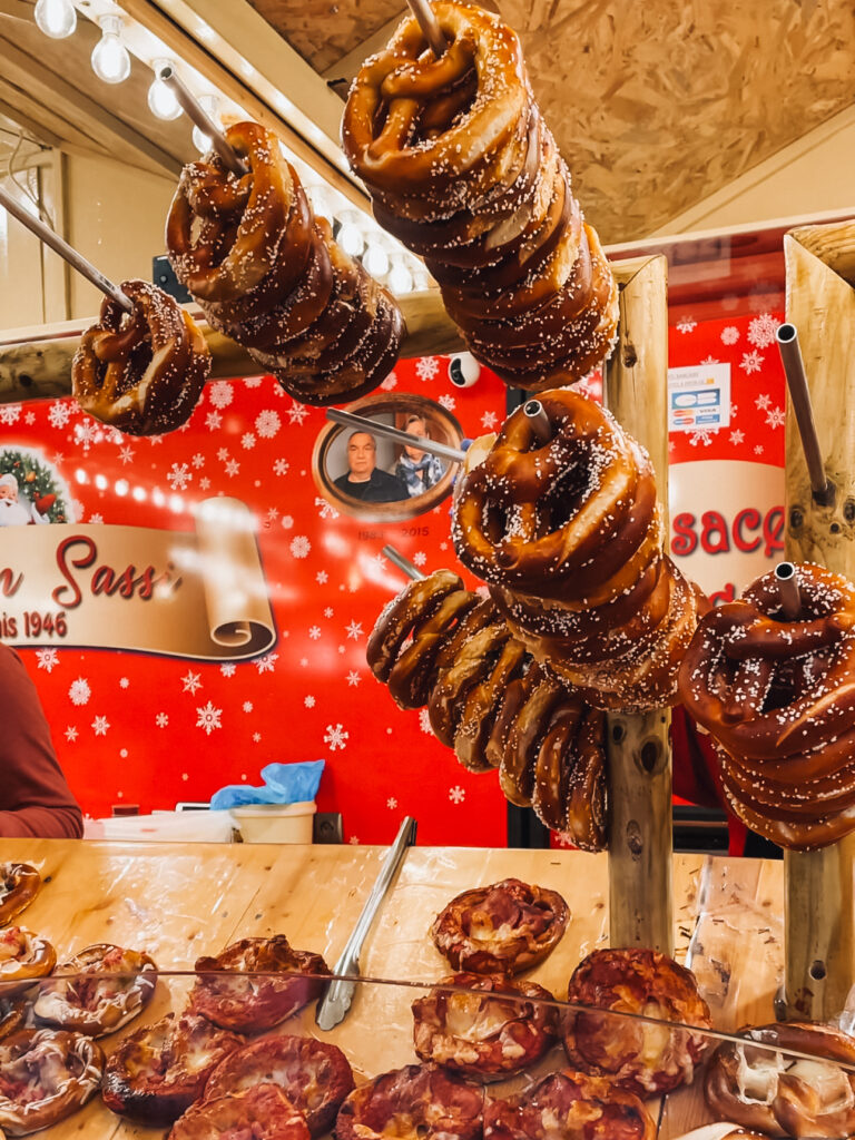 Freshly baked pretzels and savory pastries on display at a food stall in Strasbourg Christmas market.