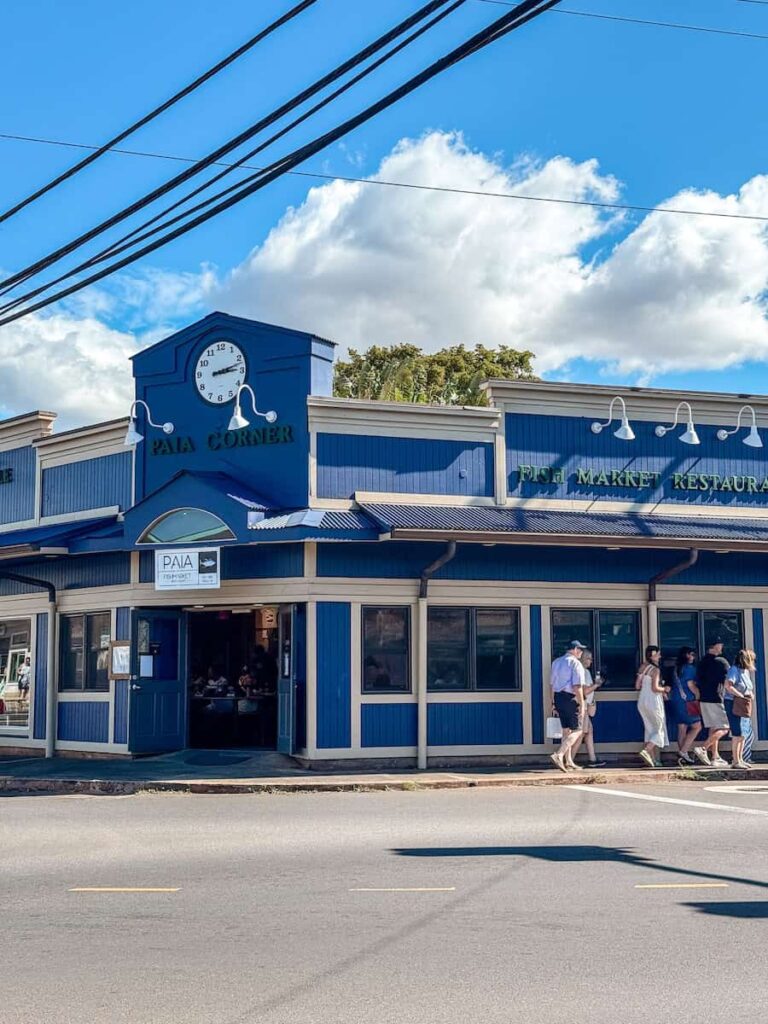 Paia Fish Market and Paia Corner building painted in deep blue with a small clock tower, a popular local restaurant in Paia, Maui.