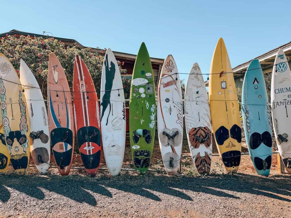 Row of colorful surfboards lined up outside in Paia, Maui, creating a vibrant local landmark near the Kuau Store.