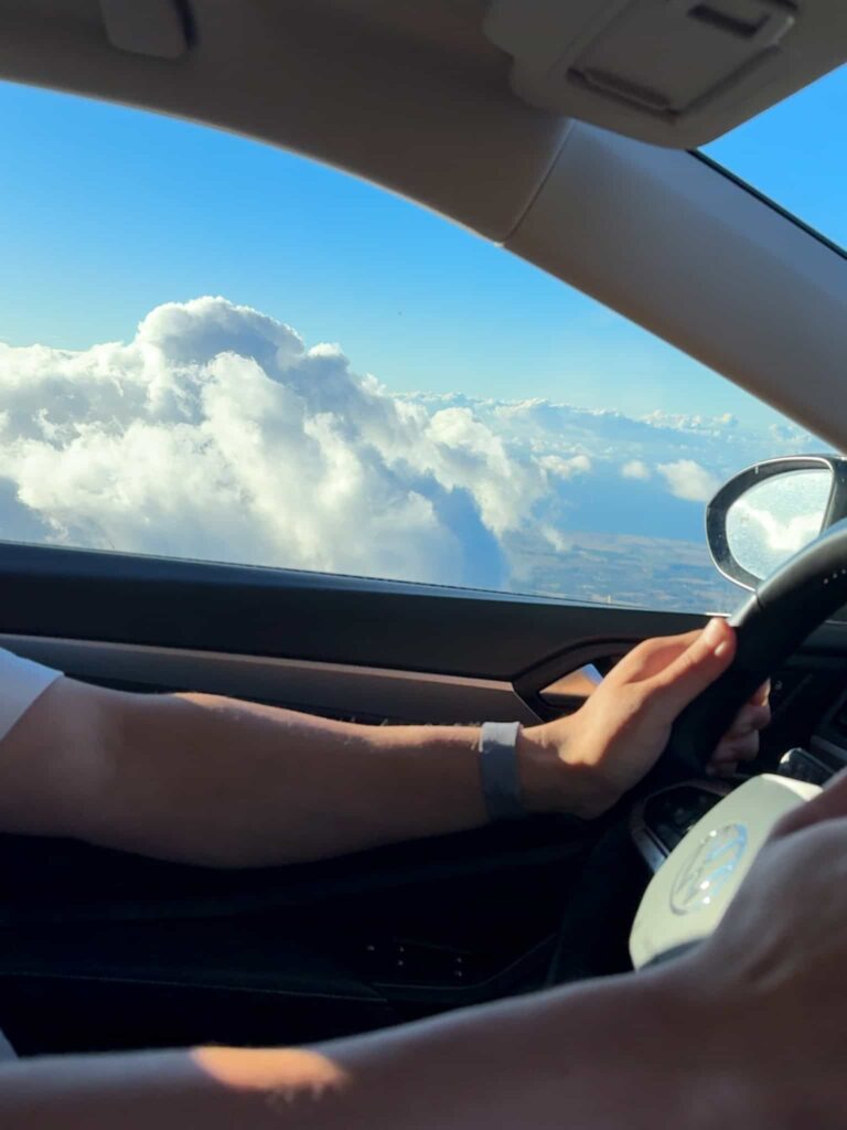 Scenic view of clouds through car window while driving up Haleakalā National Park in Maui.