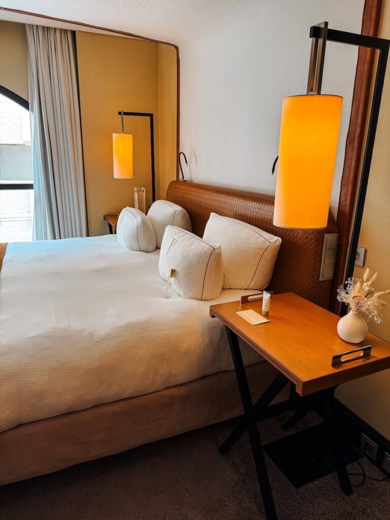 Hotel bed at Five Seas Hotel Cannes with leather headboard warm lighting and bedside table details