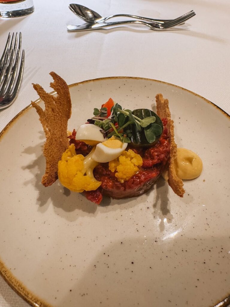 Gourmet main course at Hotel Krallerhof featuring beautifully plated meat and vegetables