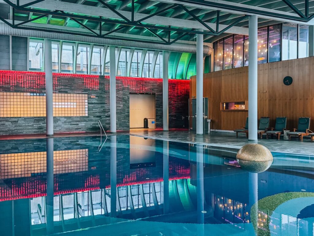 Indoor family pool at Hotel Krallerhof with colorful lighting high ceilings and reflective water