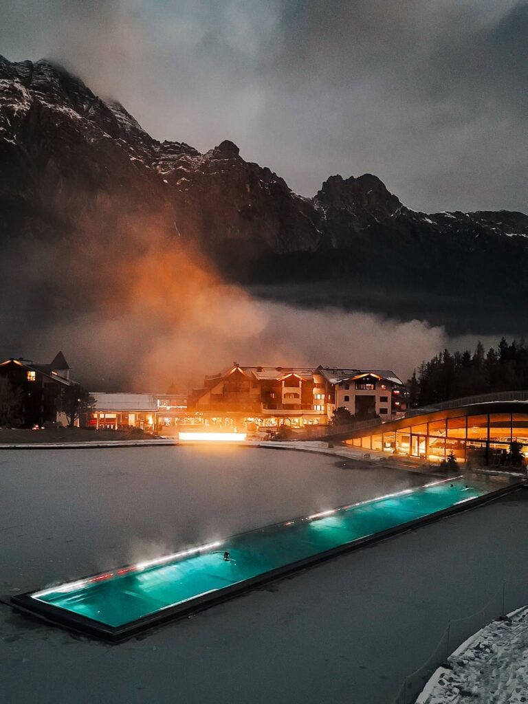 Outdoor pool at Hotel Krallerhof with snow covered surroundings and mountain backdrop in Leogang