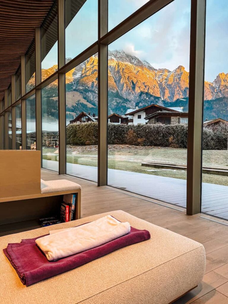 Relaxation room at Hotel Krallerhof with floor to ceiling windows loungers and mountain views at sunset