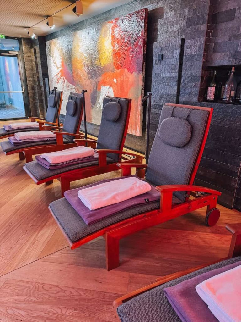 Relaxation room at Hotel Krallerhof with wooden loungers folded towels and abstract wall art