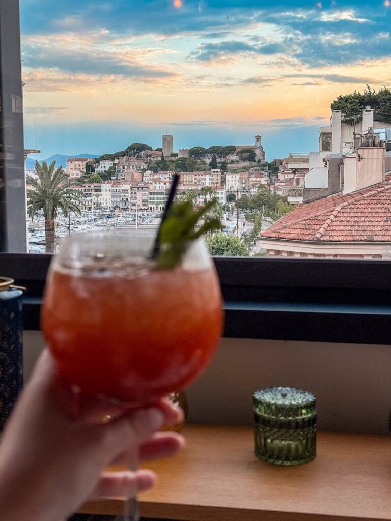 Cocktail at Le Roof restaurant overlooking Cannes Old Town and harbor at sunset