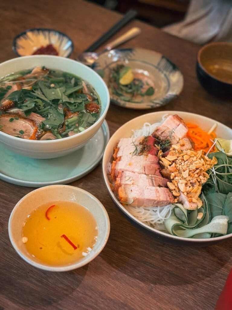 Traditional Vietnamese meal at Com Linh in Hoi An with grilled pork, fresh herbs, noodles, and dipping sauces