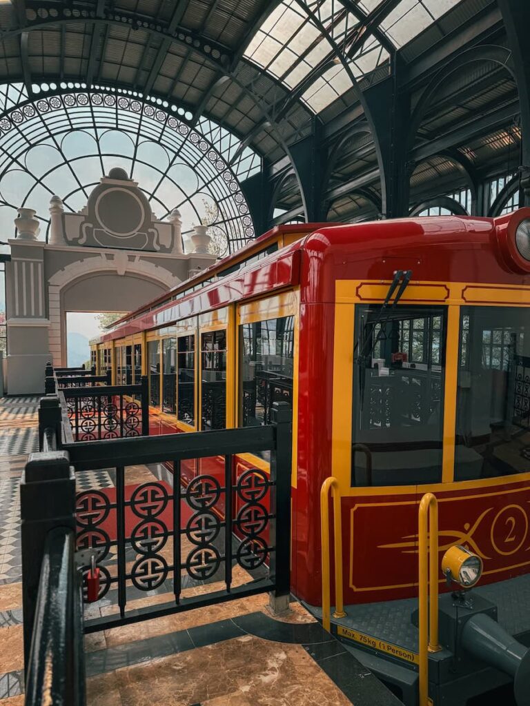 The Mường Hoa Mountain Train at Sapa Station, featuring its vintage red and yellow carriages inside the elegant glass roof terminal in Sapa, Vietnam, is one of the best things to do in Sapa Vietnam. 