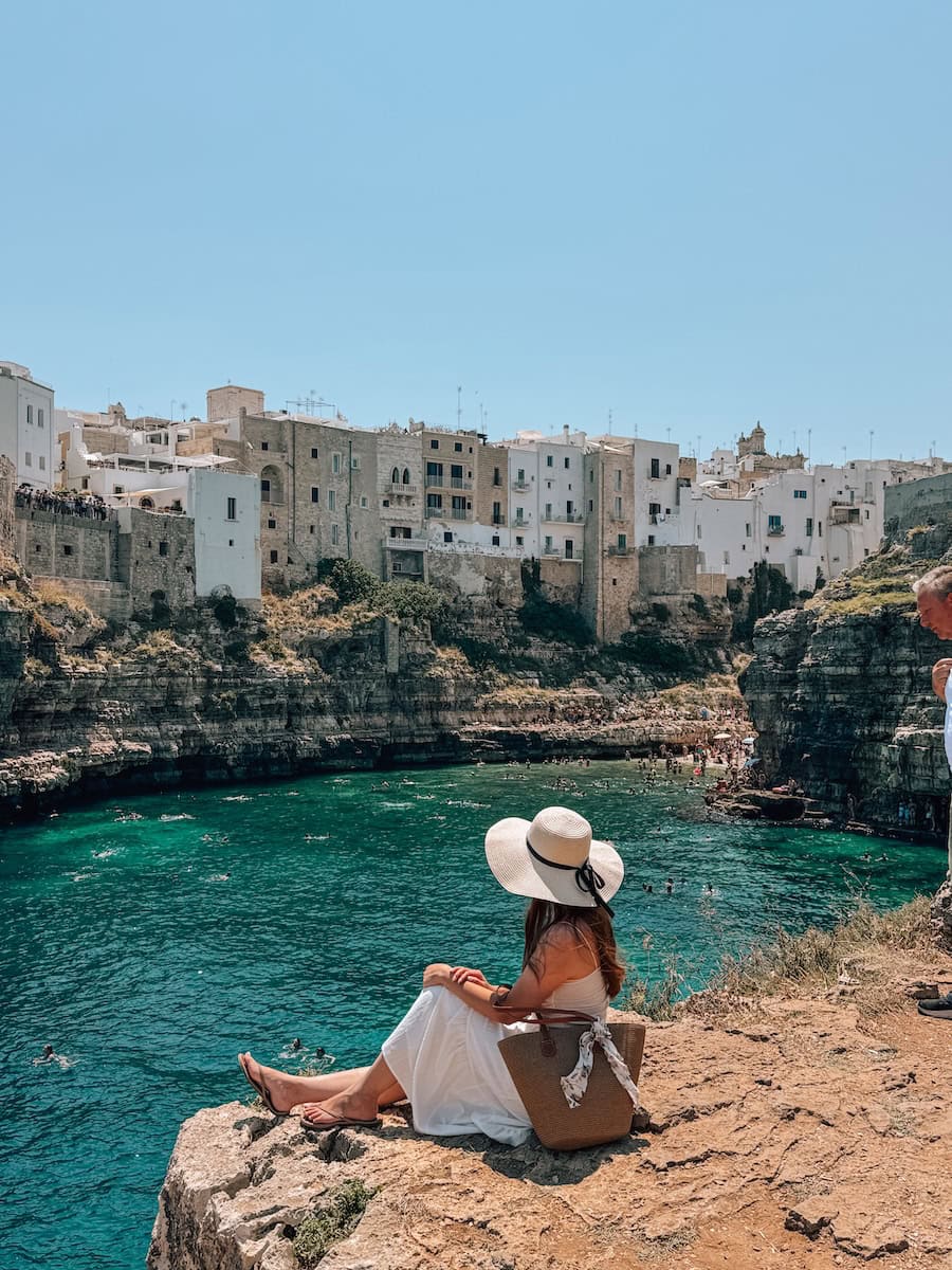 Author overlooking Lama Monachile in Polignano a Mare, with turquoise Adriatic waters, dramatic limestone cliffs, and the historic old town perched above the famous beach.