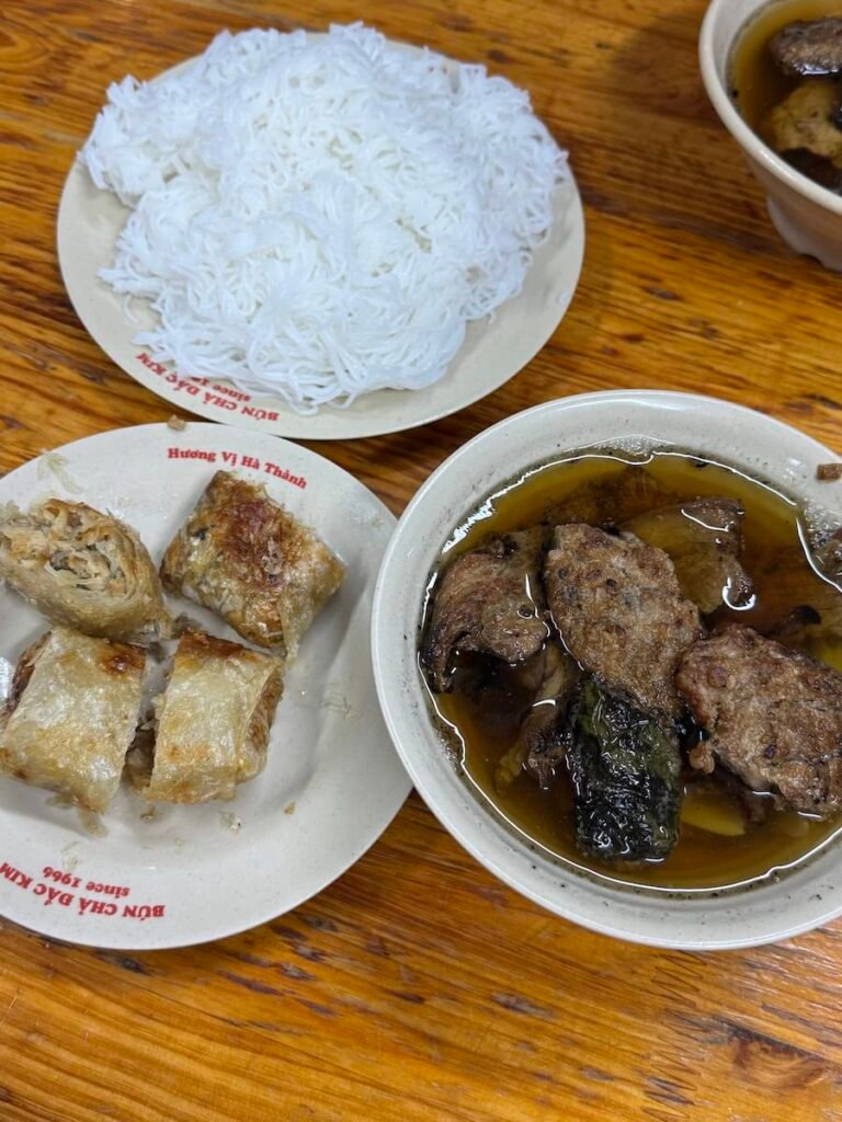 Bowl of Hanoi bun cha with grilled pork in broth, rice noodles and herbs