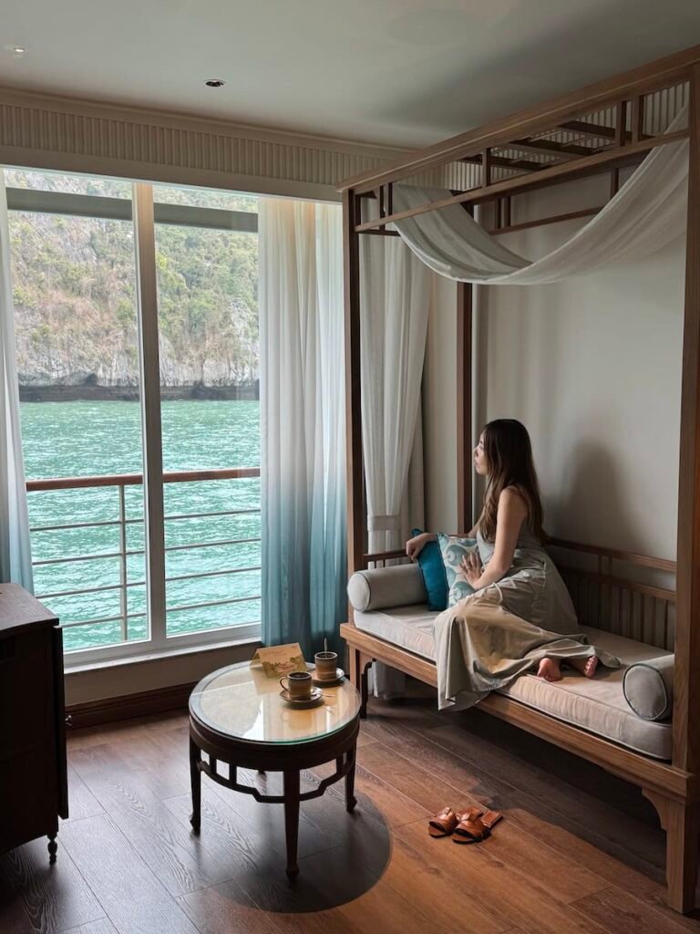 Bed and window view inside a Bhaya Soul cabin on a Ha Long Bay overnight cruise