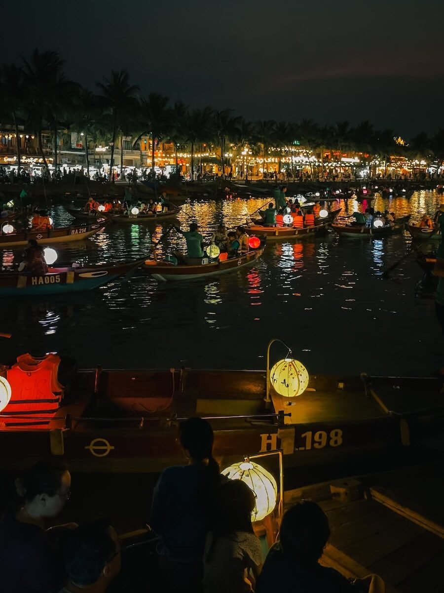 Lantern boats glowing on the Thu Bon River in Hoi An after dark